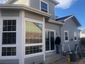 Technicians install fiberglass windows on a residential property. 